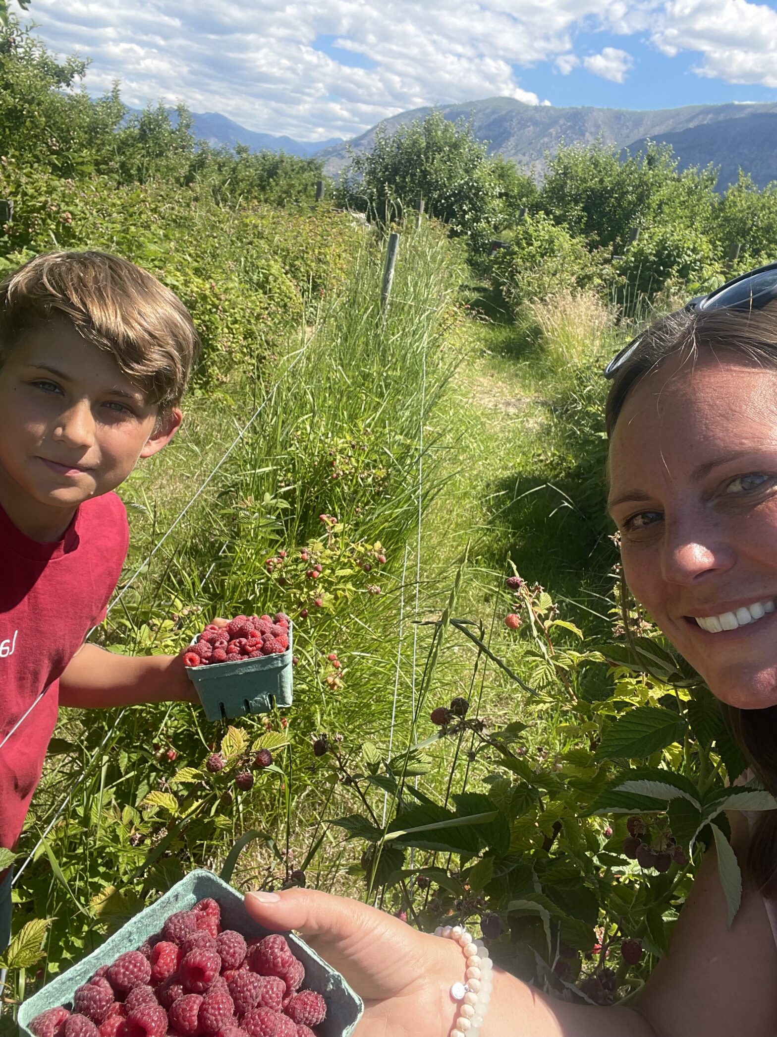 Owen and Jeana over the hump with the first ripe raspberries at Chelan Valley Farms