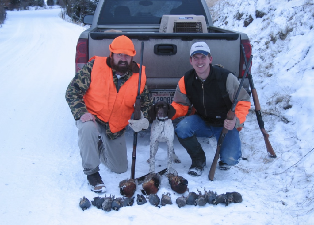 Two hunters kneeling in the snow with a German Shorthair and a limit of pheasant and quail on the Palouse, 2003